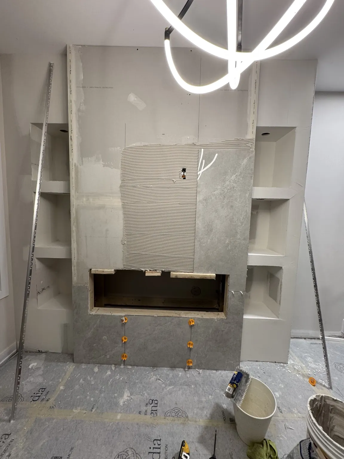 Work in progress on a tiled fireplace feature wall